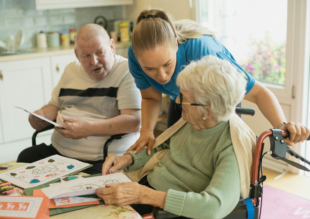 A carer sitting with an older couple in their home